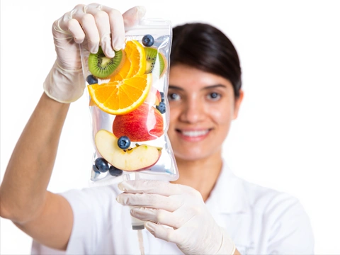 Девушка держит капельницу с фруктами