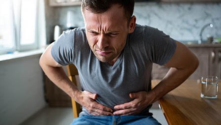 Мужчина держится за живот руками