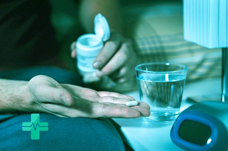 Мужчина держит в руке таблетку антидепрессантов